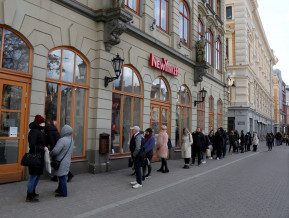 Cilvēki stāv rindā pie apģērbu veikala
