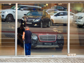 Logu mazgātājs pie luksusa klases autosalona skatloga, ilustratīvs attēls